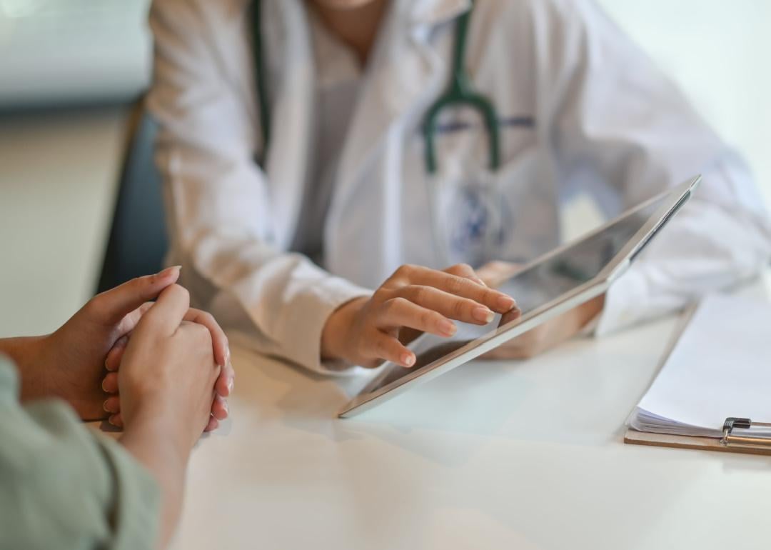Doctor showing patient information on a digital tablet.