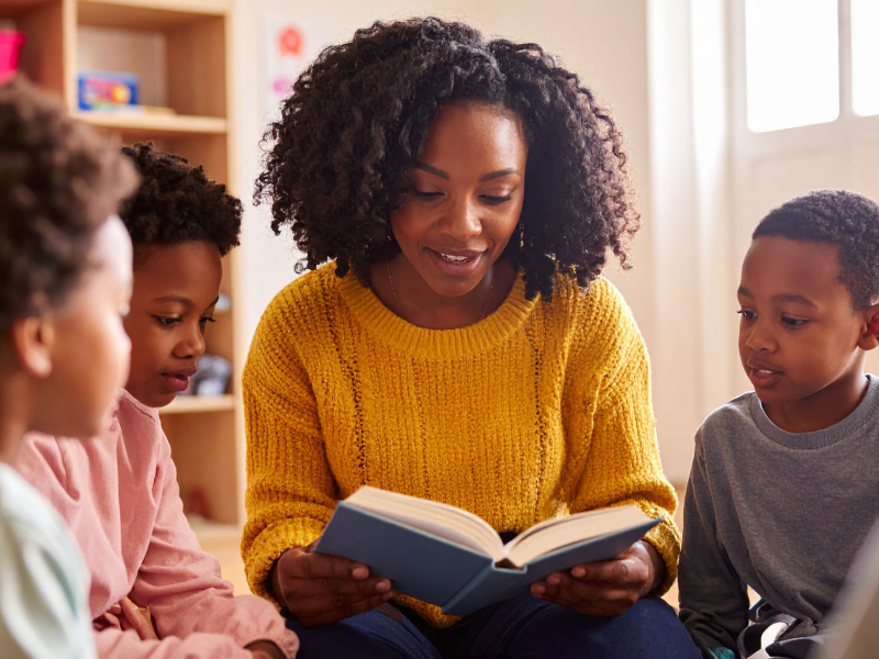 An elementary school teacher helps students with reading instruction in an Ohio classroom.
