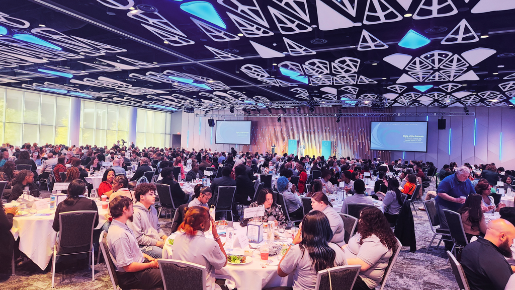 Photo of a crowded ballroom seated during the State of the School Address 