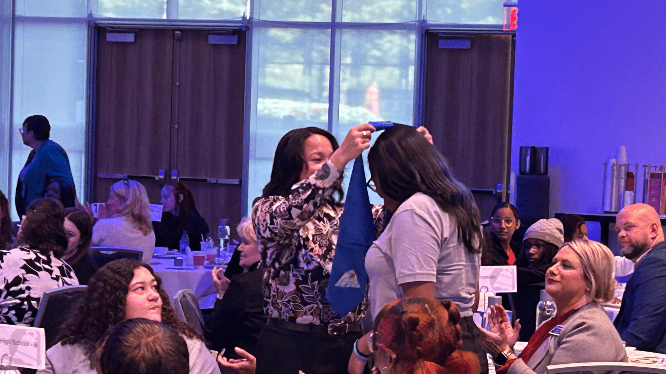 CMSD teacher puts sash on new student IMPACT leader. 